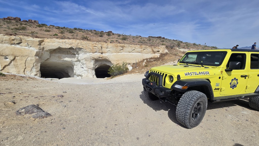 High velocity yellow highlander outside of the Holly Ash Mines. Two large mine openings showing.